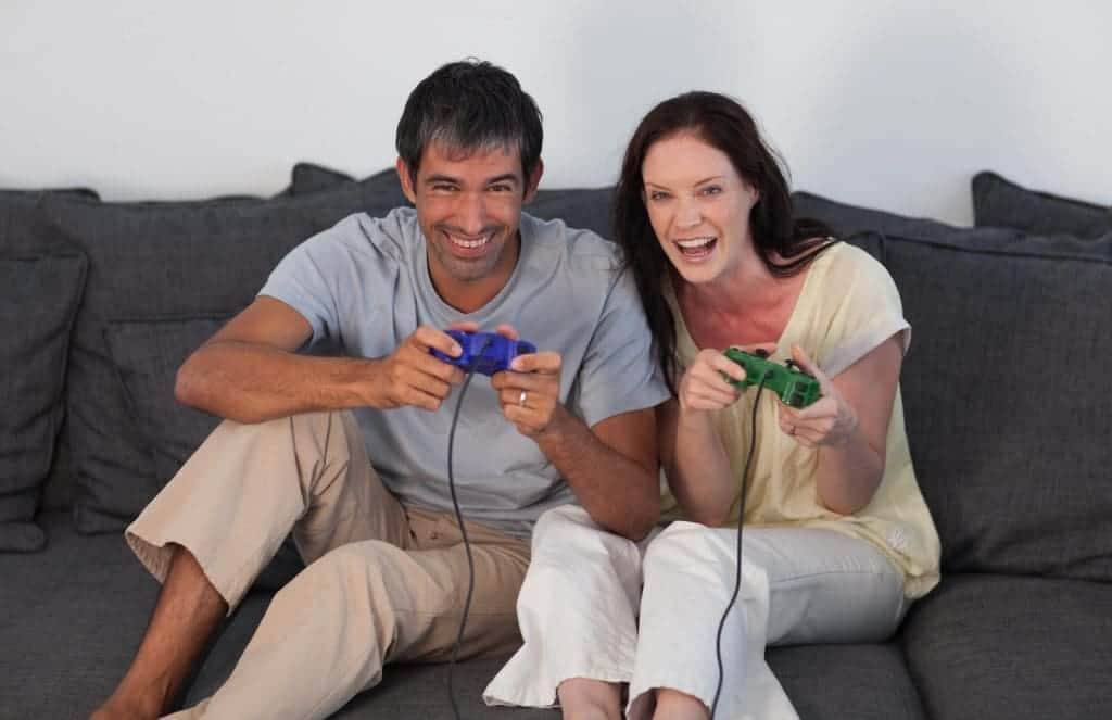 7103646 laughing couple playing video games