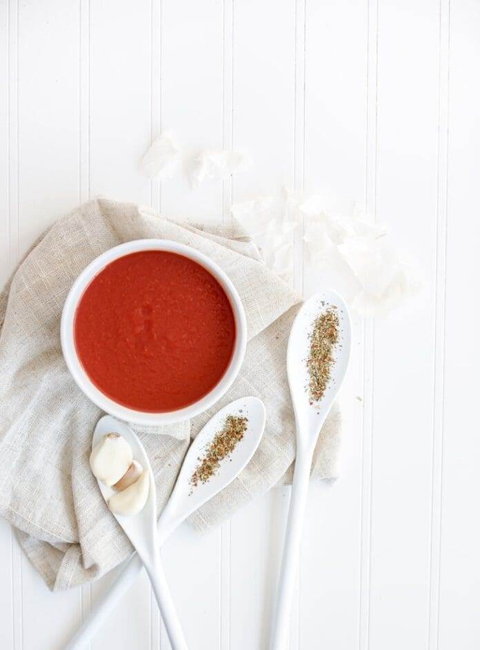 Tomato soup in a bowl with spoons around it - an example of what foods are easy to digest