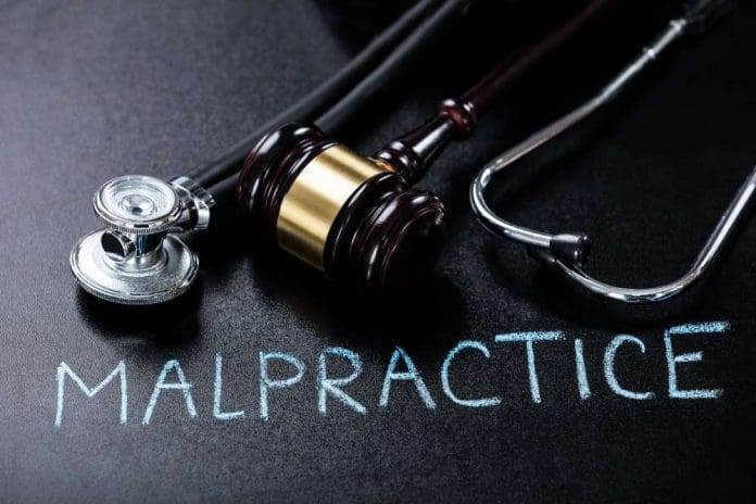 Malpractice Concept Showing Gavel And Stethoscope On Blackboard.