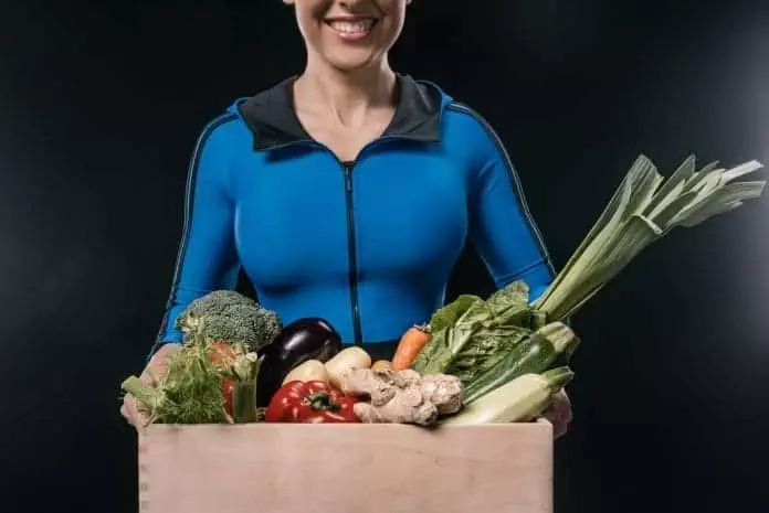 Sportswoman with fresh vegetables. Source: